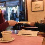 Idée de date : deux personnes en café, première rencontre, mains qui se frôlent